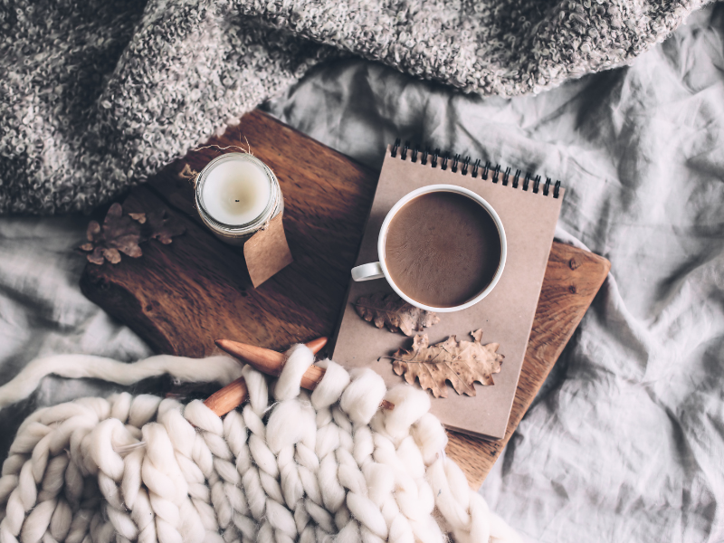 Notizbuch mit Kerze, Tasse Kaffee und Strickdecke – Hygge Idee Herbst für Achtsamkeit und Ruhe