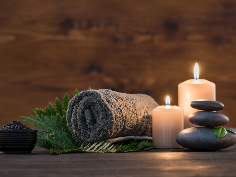 Minimalistisches Spa-Geschenk mit Handtuch, Kerzen und Natursteinen – perfekte Geschenkidee für Entspannung und Achtsamkeit.